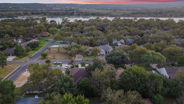 aerial view at dusk featuring a water view