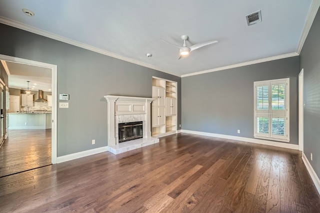 unfurnished living room featuring a fireplace, ornamental molding, ceiling fan, and dark wood-type flooring