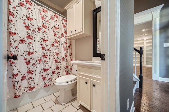 full bathroom with hardwood / wood-style floors, vanity, crown molding, toilet, and shower / bath combo with shower curtain