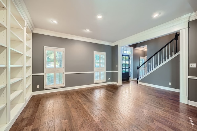 empty room with dark hardwood / wood-style flooring, a wealth of natural light, and ornamental molding