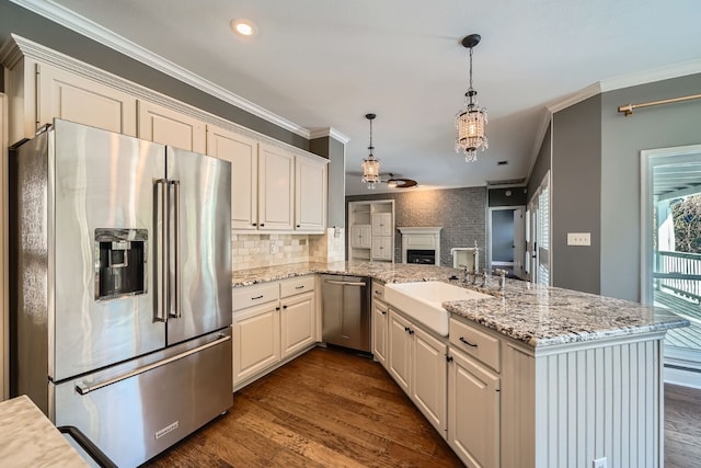 kitchen featuring hanging light fixtures, dark wood-type flooring, stainless steel appliances, kitchen peninsula, and crown molding