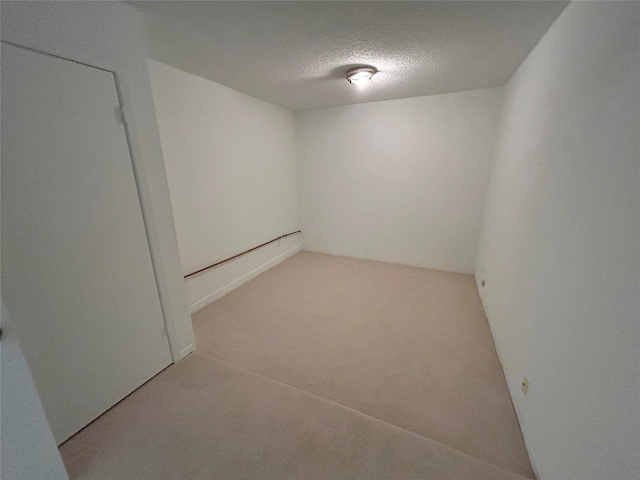 basement featuring carpet flooring and a textured ceiling