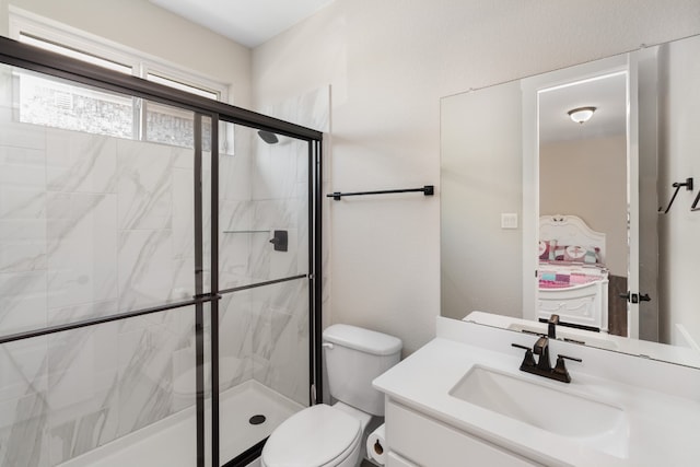 bathroom featuring vanity, toilet, and a shower with door