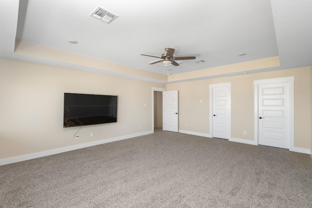 unfurnished bedroom featuring carpet floors, a raised ceiling, and ceiling fan