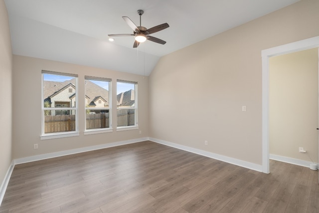 unfurnished room featuring ceiling fan, light hardwood / wood-style floors, and vaulted ceiling