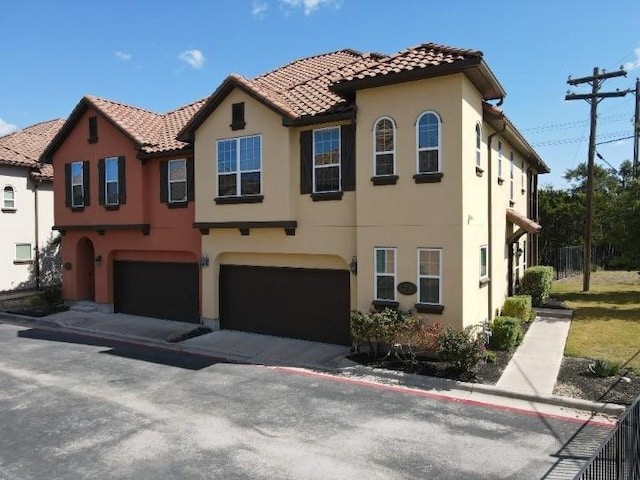 view of front of property with a garage, stucco siding, and a tiled roof