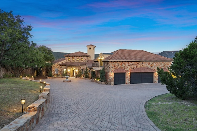 mediterranean / spanish house with a yard and a garage