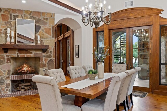 dining space featuring a fireplace, a chandelier, and hardwood / wood-style flooring