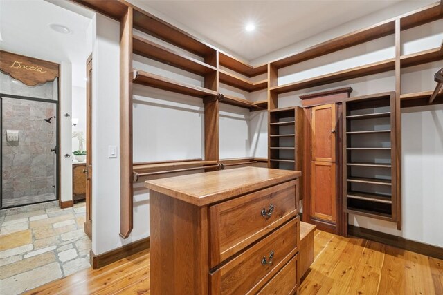 walk in closet with light hardwood / wood-style flooring