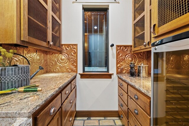 kitchen with light stone countertops, light wood-type flooring, backsplash, and oven