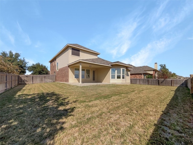 rear view of property featuring a yard and a patio