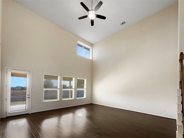 spare room featuring dark hardwood / wood-style floors, ceiling fan, and high vaulted ceiling