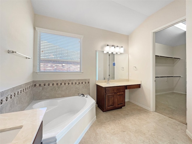 bathroom featuring vanity, a bath, and vaulted ceiling