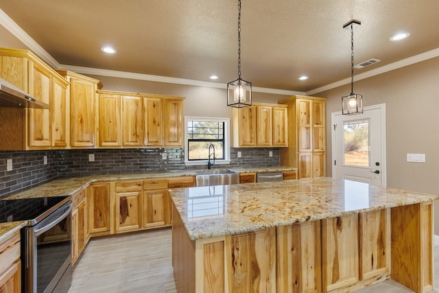 kitchen with a center island, appliances with stainless steel finishes, pendant lighting, and sink