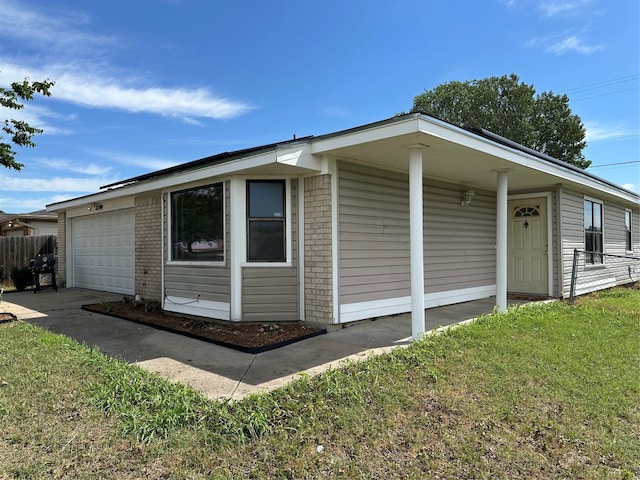 view of property exterior with covered porch, a garage, and a yard