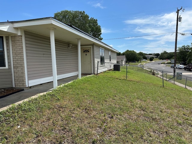 view of side of property with a yard and central air condition unit