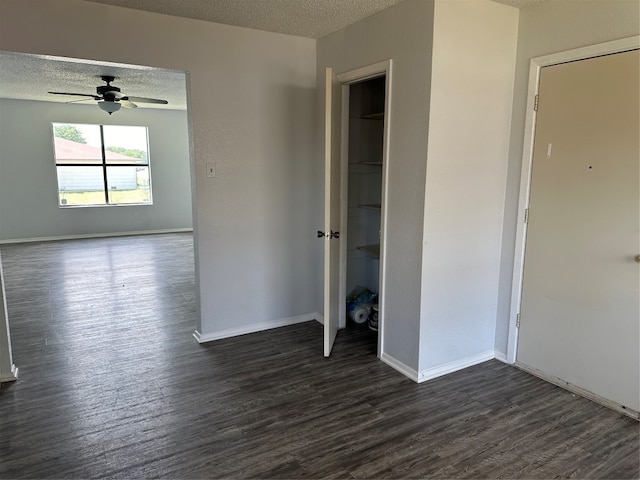 unfurnished bedroom with ceiling fan, dark hardwood / wood-style flooring, and a textured ceiling