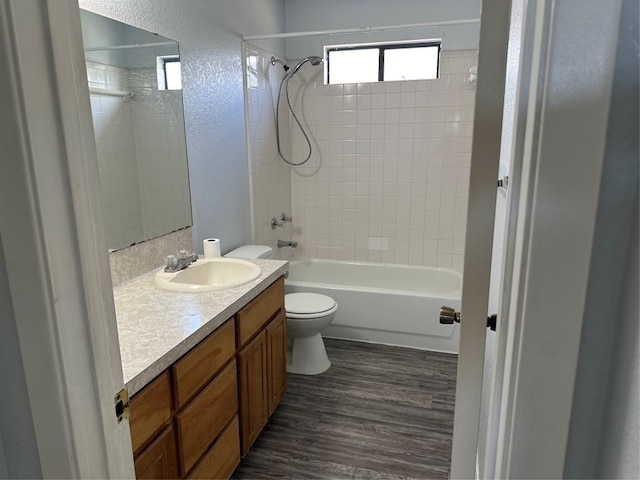 full bathroom with vanity, tiled shower / bath combo, hardwood / wood-style flooring, and toilet