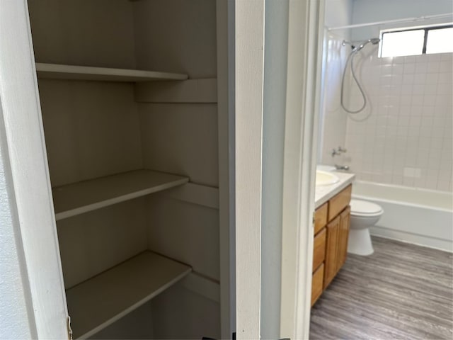 full bathroom with vanity, toilet, wood-type flooring, and bathtub / shower combination