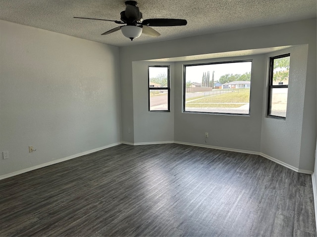 unfurnished room featuring a textured ceiling, dark hardwood / wood-style flooring, and plenty of natural light