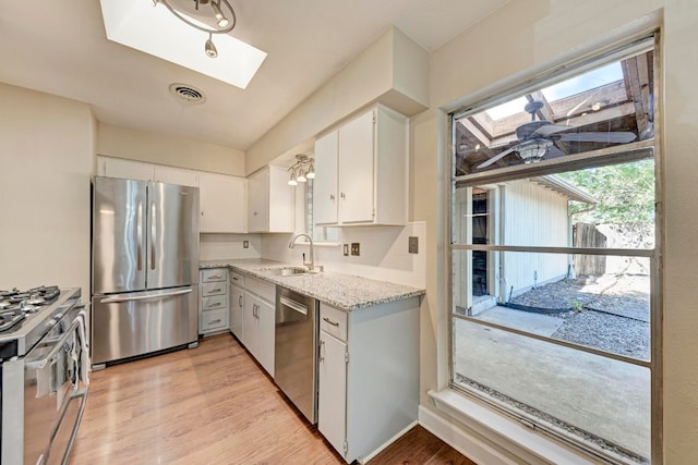 kitchen featuring sink, white cabinets, stainless steel appliances, and light hardwood / wood-style floors