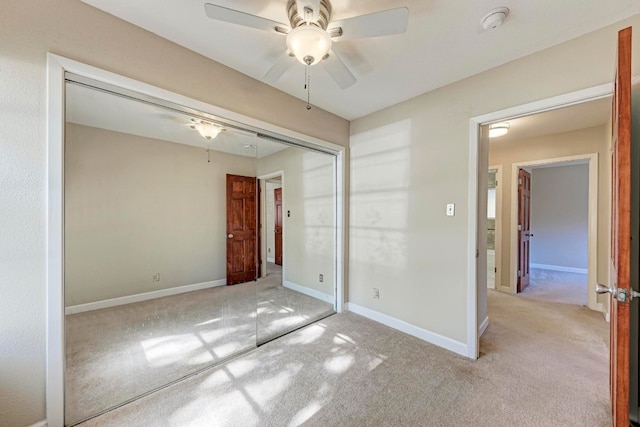 unfurnished bedroom featuring light colored carpet, a closet, and ceiling fan