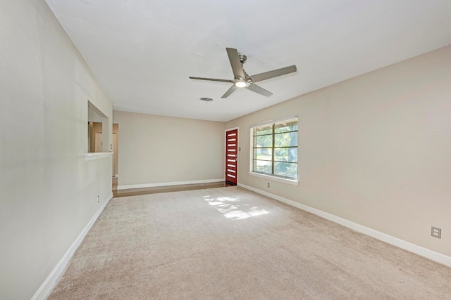 spare room with ceiling fan and light colored carpet