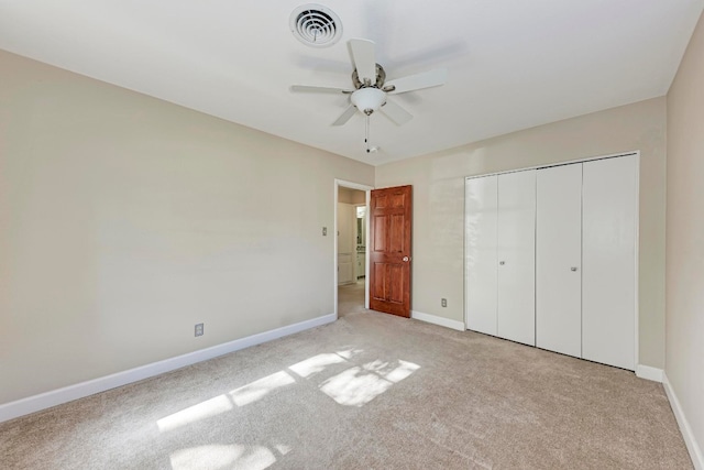 unfurnished bedroom featuring light carpet, a closet, and ceiling fan