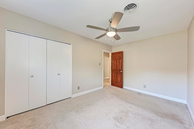 unfurnished bedroom featuring ceiling fan, a closet, and light carpet