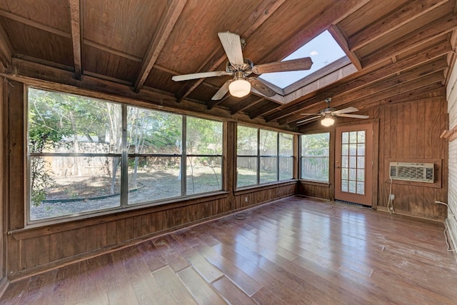 unfurnished sunroom featuring ceiling fan, lofted ceiling with skylight, a wall mounted air conditioner, and wooden ceiling