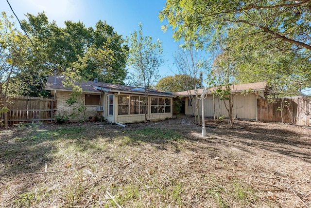 back of property with a sunroom