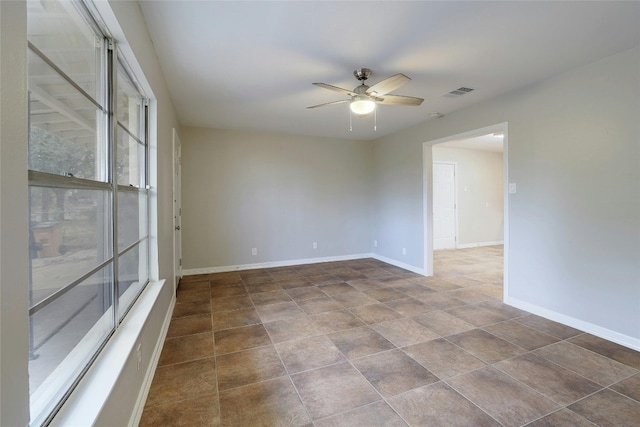 tiled spare room featuring ceiling fan