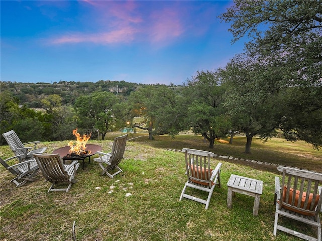 yard at dusk featuring an outdoor fire pit