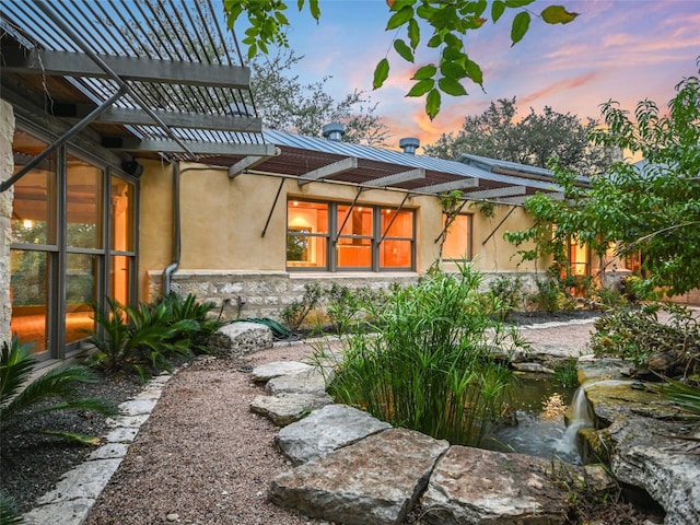 yard at dusk featuring a pergola