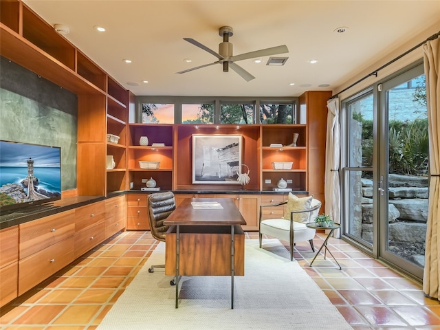 office featuring ceiling fan, light tile patterned flooring, and built in desk