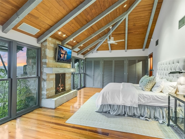 bedroom with multiple windows, hardwood / wood-style floors, and beamed ceiling