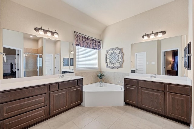 19316 Chayton Cir, Pflugerville, TX 78660 - bathroom with a stall shower, vaulted ceiling, a bath, two vanities, and tile patterned floors