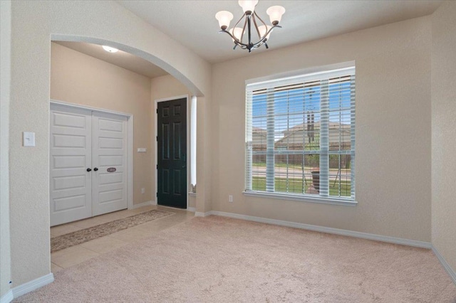 19316 Chayton Cir, Pflugerville, TX 78660 - carpeted foyer featuring arched walkways, a chandelier, plenty of natural light, and baseboards