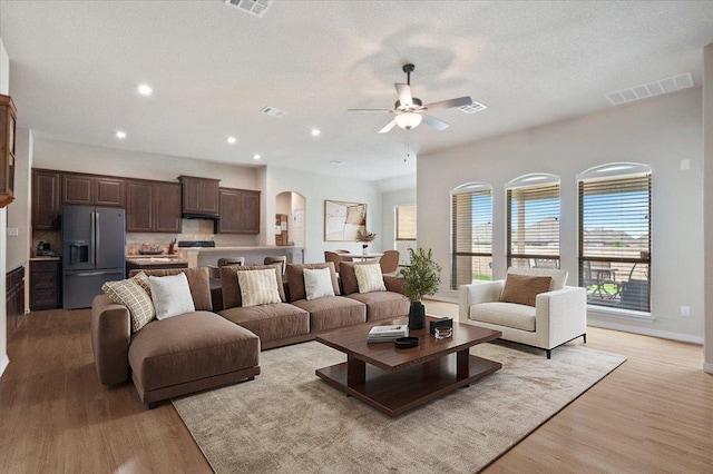 19316 Chayton Cir, Pflugerville, TX 78660 - living area featuring a ceiling fan, light wood-style flooring, recessed lighting, arched walkways, and baseboards
