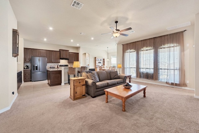 19316 Chayton Cir, Pflugerville, TX 78660 - living room featuring ceiling fan, light colored carpet, baseboards, arched walkways, and recessed lighting