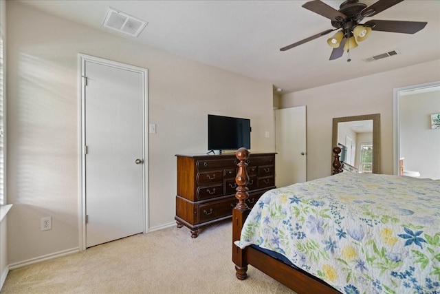 carpeted bedroom with multiple windows, ceiling fan, and ensuite bathroom