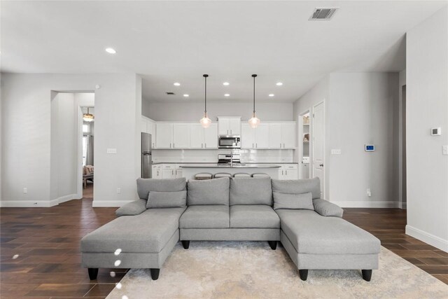 living area featuring recessed lighting, wood finished floors, visible vents, and baseboards
