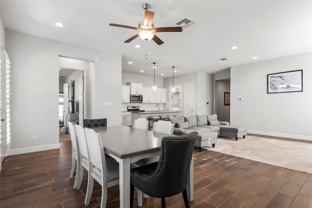 dining space featuring ceiling fan, dark hardwood / wood-style floors, and sink