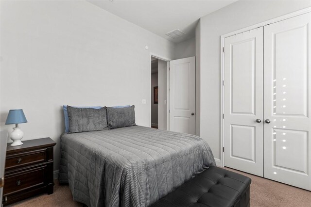 carpeted bedroom with a closet and visible vents