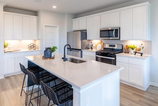 kitchen featuring white cabinetry, an island with sink, appliances with stainless steel finishes, and sink