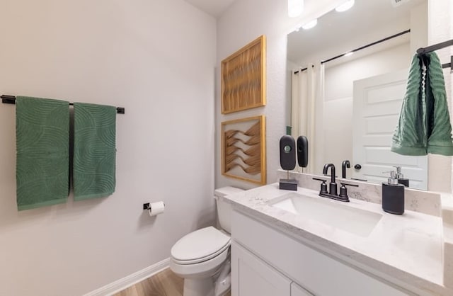 bathroom featuring hardwood / wood-style flooring, vanity, and toilet