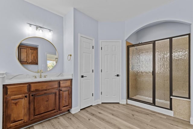 bathroom with wood-type flooring, vanity, and walk in shower