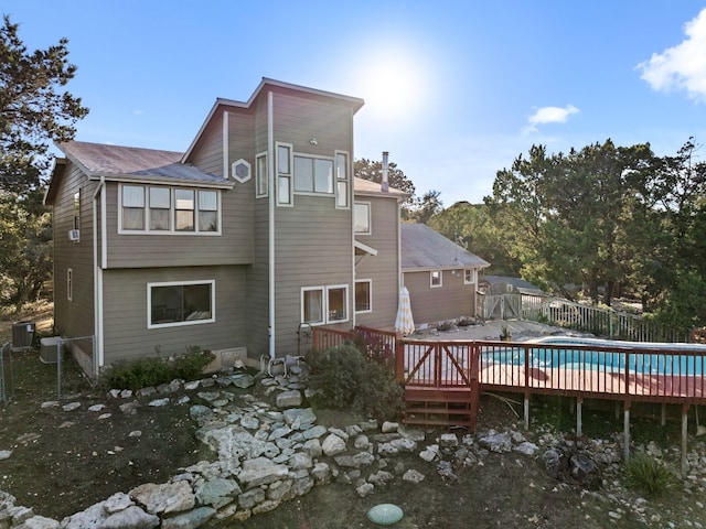 back of property featuring central AC unit and a wooden deck