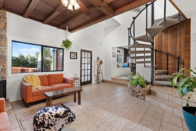 tiled living room with beamed ceiling, ceiling fan, wood ceiling, and a towering ceiling