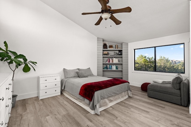 bedroom featuring a textured ceiling, light hardwood / wood-style flooring, ceiling fan, and lofted ceiling